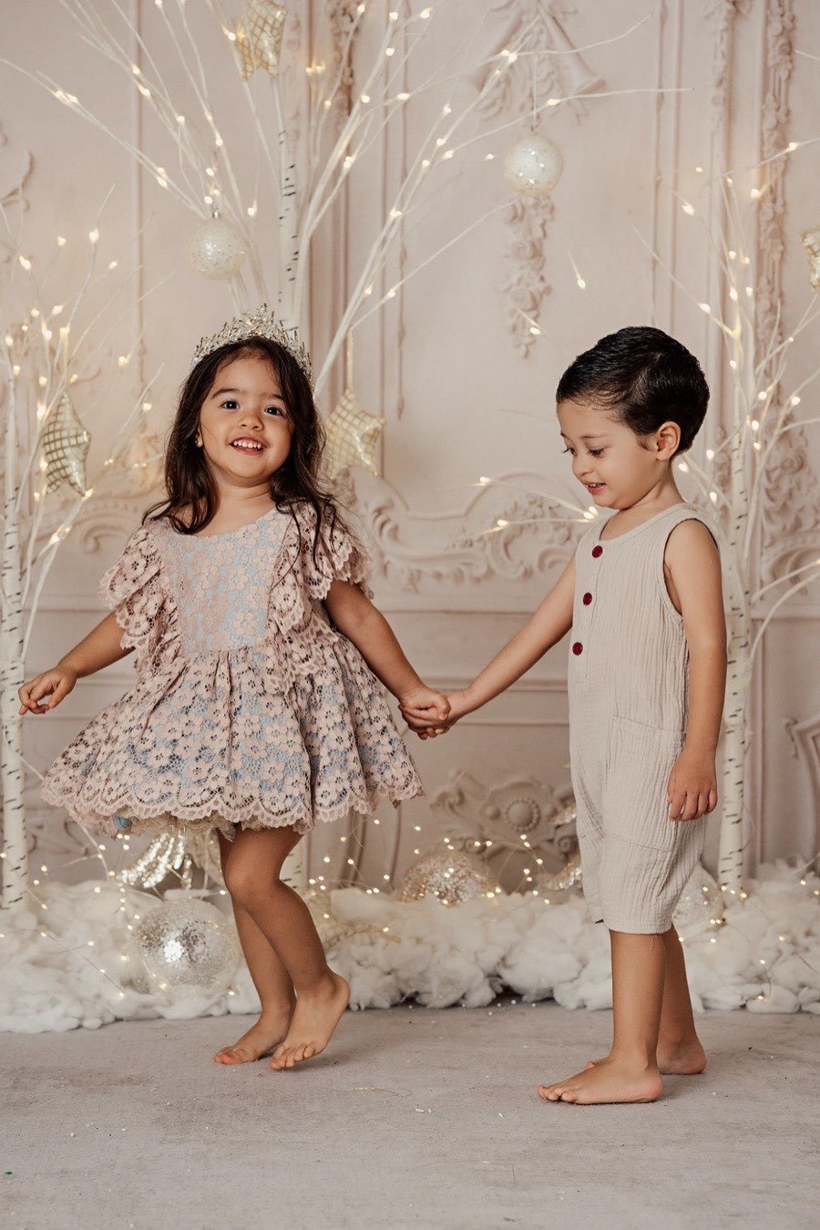 Niña bailando de la mano de su hermano
