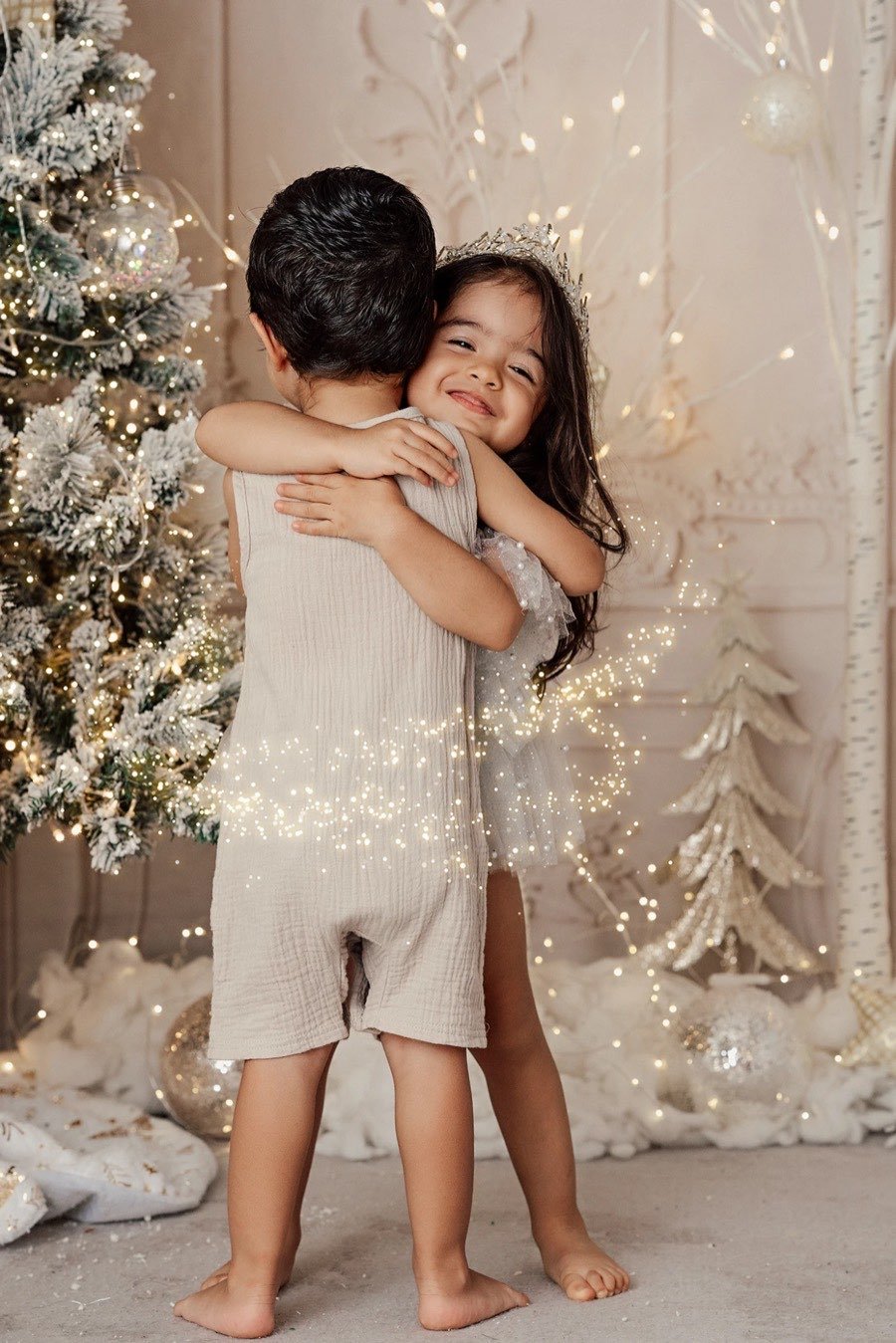 Niña abrazando a su hermano y sonriendo
