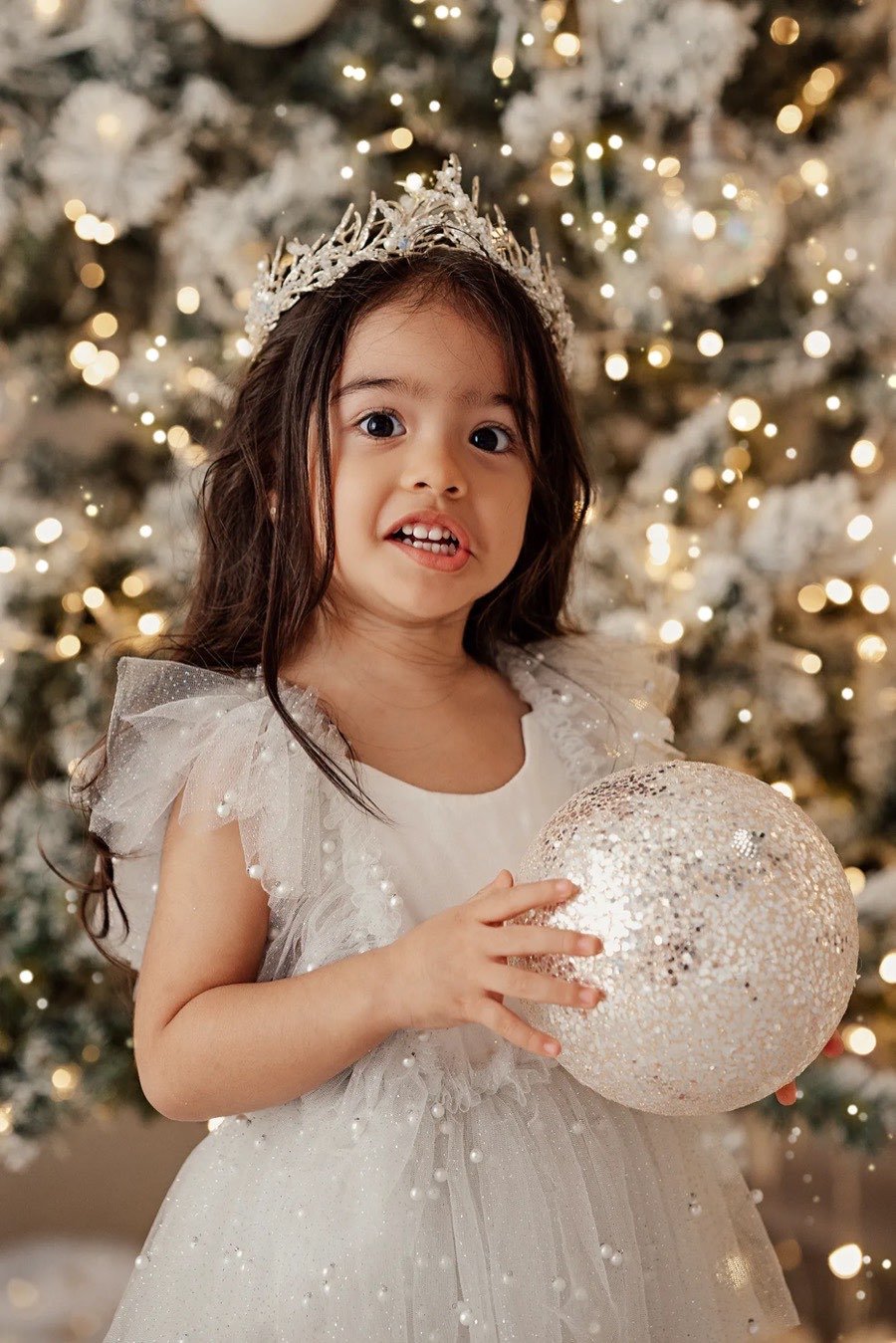 Niña con corona y esfera, cara de sorpresa